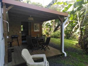 a wooden deck with a table and chairs at Studio dans la forêt tropicale in Les Anses-dʼArlets