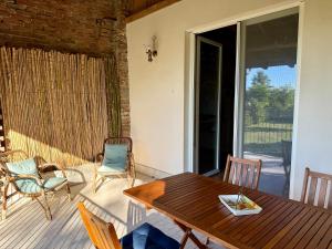 a patio with a wooden table and chairs on a porch at Monferrato Guest House - Il Murôn in Carentino