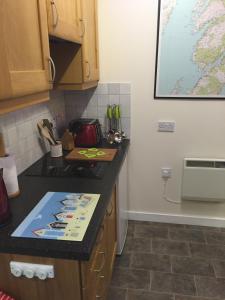 a kitchen with a black counter top and a counter top at Artisan Studio in Tarbert