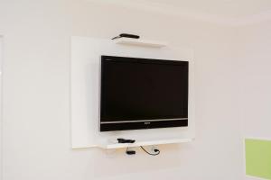 a flat screen tv sitting on a white wall at Novo Maanaim Hotel in Presidente Epitácio
