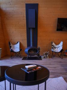 a living room with a fireplace and a table and chairs at Vino Chalets Bran in Sohodol