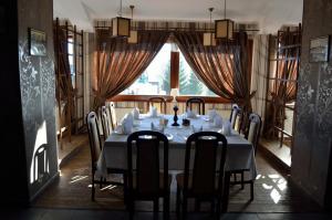 a dining room with a table and chairs and a window at Hotel Rusu in Petroşani