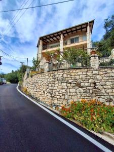 a stone wall in front of a building at AGAPI Holiday House in Vouníon