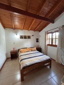 a bedroom with a bed in a room with wooden ceilings at Cabañas Kidamalau in Merlo +13 photos