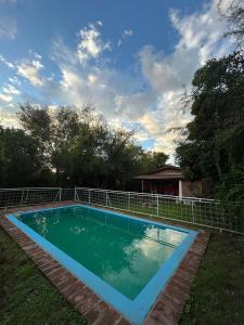 a swimming pool in the yard of a house at Cabañas Kidamalau in Merlo