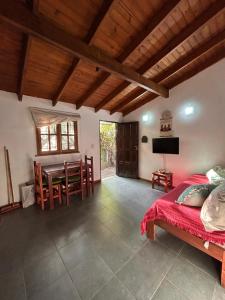 a bedroom with a bed and a table and chairs at Cabañas Kidamalau in Merlo