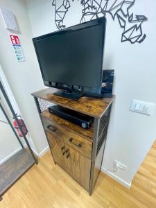 a flat screen tv on a wooden entertainment center at Appartamento - Mini Suite in Brescia