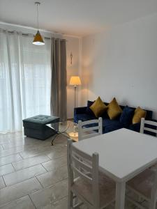 a living room with a white table and a blue couch at Bejart Apartment 8 in Tirana +7 photos