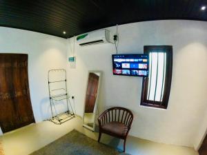 a room with a chair and a sign on a wall at The Loons Lake Villa in Tangalle