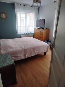 a bedroom with a bed and a dresser and a television at La Maison Elegance & Charme in Marquise +9 photos