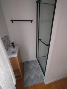 a bathroom with a glass shower door next to a sink at La Maison Elegance & Charme in Marquise