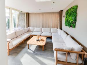 a living room with a white couch and a table at Villa with jacuzzi & sauna 500m from beach in Middelkerke +32 photos