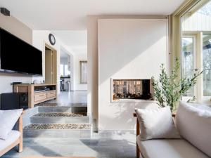 a living room with a couch and a fireplace at Villa with jacuzzi & sauna 500m from beach in Middelkerke