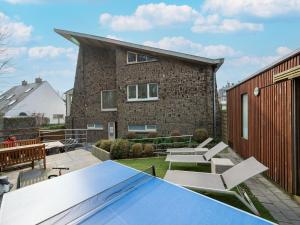 a patio with a table and chairs and a building at Villa with jacuzzi & sauna 500m from beach in Middelkerke