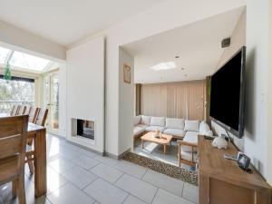a living room with a couch and a tv at Villa with jacuzzi & sauna 500m from beach in Middelkerke