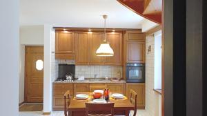 a kitchen with wooden cabinets and a table with chairs at Casa Savilla by Ca-Sa Check in Pieve di Cadore +79 photos