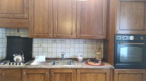 a kitchen with wooden cabinets and a sink at Casa Savilla by Ca-Sa Check in Pieve di Cadore
