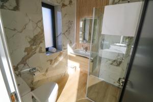 a bathroom with a shower and a toilet and a sink at An Tobar in Ballina +12 photos