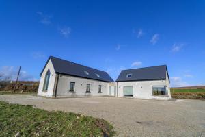 a large white building with a black roof at An Tobar in Ballina