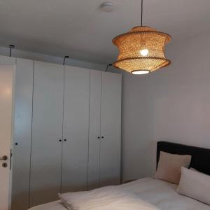 a bedroom with a bed and a chandelier at Gemütlich wohnen nahe Frankfurt in Karben