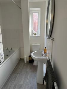 a white bathroom with a sink and a tub and a mirror at 2 Millway in Golden Valley