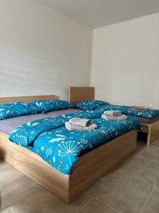 a bedroom with two beds with blue comforter at Apartmán U Štýbnarů in Bulhary