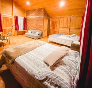 a bedroom with two beds and a couch at Entrecafe Experience- Los Naranjos in Ojo de Agua