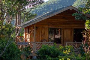 a log cabin in the woods with a porch at Entrecafe Experience- Los Naranjos in Ojo de Agua