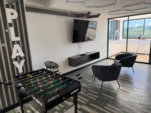 a room with a pool table and two chairs at Boreal House in Manizales