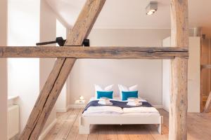 a loft bed with blue pillows in a bedroom at OSTKÜSTE - Villa Albatros Design Apartments in Ahlbeck