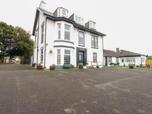 a white house with a black roof at Seaview Wellness Retreat in Carnoustie