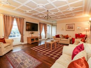 a large living room with a coffered ceilings and a living room with couches at Seaview Wellness Retreat in Carnoustie