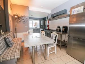 a kitchen with a table and chairs and a refrigerator at Seaview Wellness Retreat in Carnoustie