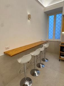 a bar with white stools in a room at L'Atrio Suite in Torre del Greco