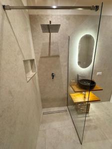 a bathroom with a glass shower with a sink at L'Atrio Suite in Torre del Greco