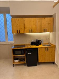 a kitchen with wooden cabinets and a sink at L'Atrio Suite in Torre del Greco +11 photos