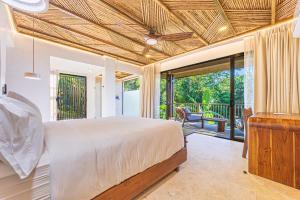 a bedroom with a bed and a balcony at Tiki Villas Rainforest Lodge - Adults Only in Uvita +108 photos