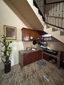 a kitchen with wooden cabinets and a staircase at Good Feeling Ijen Banyuwangi in Banyuwangi