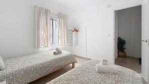 a white room with two beds and a window at Villa Almirante Torrecilla by South Costa in Nerja