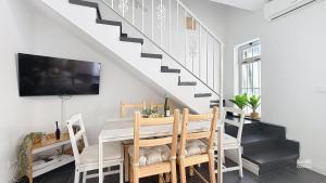 a dining room with a table and a tv and stairs at Villa Almirante Torrecilla by South Costa in Nerja