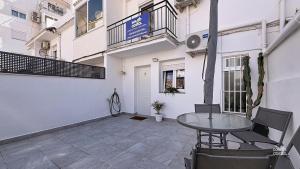 a patio with a table and chairs in front of a building at Villa Almirante Torrecilla by South Costa in Nerja