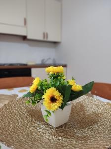 a vase filled with yellow flowers on a table at "Babbo" Nicola in Salve +4 photos