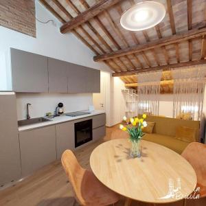 a kitchen and a table with a vase of flowers on it at La Bricola - Buora in Chioggia +12 photos