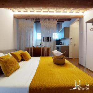 a bedroom with a large bed with a yellow blanket at La Bricola - Buora in Chioggia