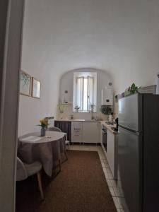 a kitchen with a table and a refrigerator at Gioberti in Casale Monferrato