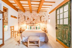 a bedroom with a bed and a stone wall at Calma Hotel in Ciutadella
