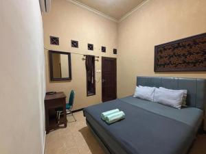 a bedroom with a bed and a desk and a desk at Good Feeling Ijen Banyuwangi in Banyuwangi