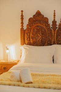 a close up of a bed with a wooden headboard at Refúgio da Cancela - Arouca Stay in Arouca +76 photos