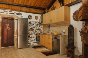 a kitchen with a stainless steel refrigerator and wooden cabinets at Refúgio da Cancela - Arouca Stay in Arouca