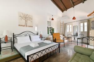 a bedroom with a bed and a couch at Tepeleni, Parga Apts with Pool in Agiá